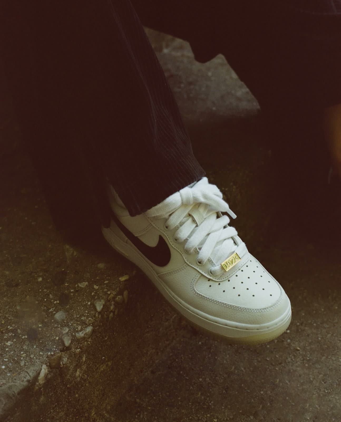 Close-up of a white Air Force 1 with a gold lace tag