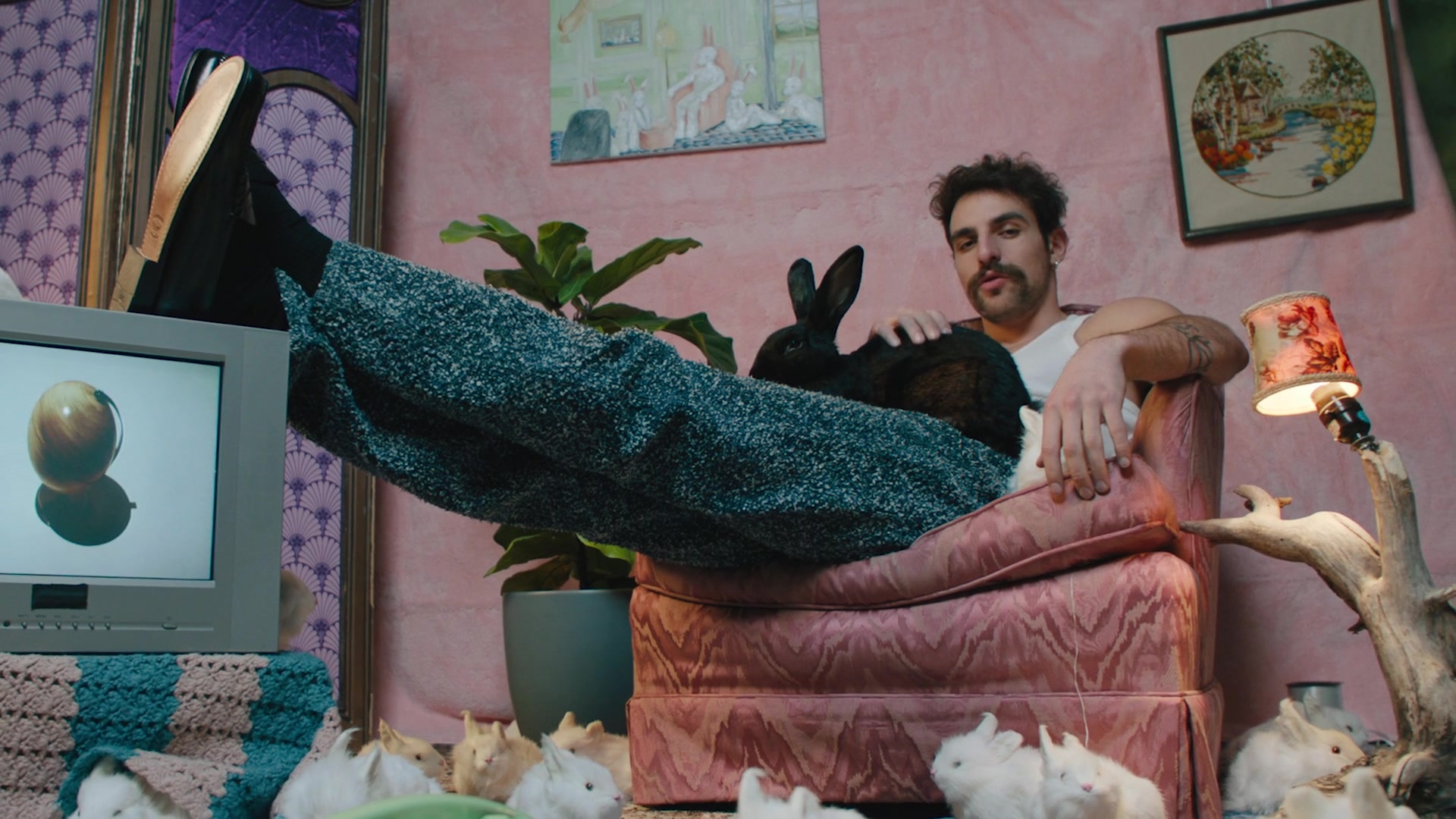 Speckled knit trousers on a pink armchair, with rabbits