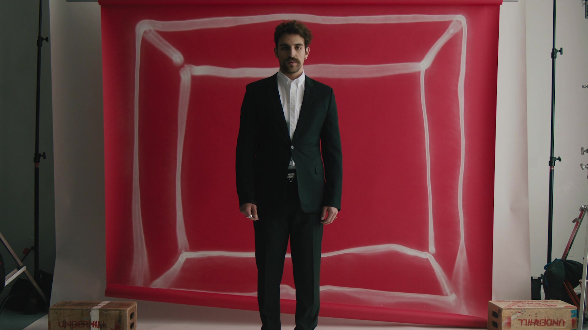 Black suit before the red painted backdrop